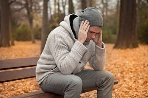 man sitting on bench feeling the effects of opioid addiction